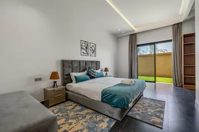 a bedroom with a bed and a couch at Red villa, pool not overlooked in Oulad Akkou