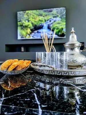 a table with two plates of food and a tv at Luxury villa, private heated pool, jacuzzi, games in Oulad Akkou
