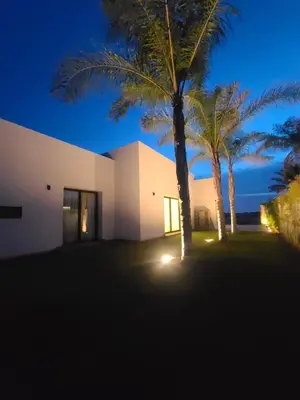 a building with two palm trees in front of it at Luxury villa, private heated pool, jacuzzi, games in Oulad Akkou
