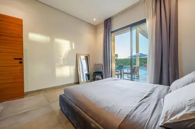 a bedroom with a bed and a large window at Luxury villa, private heated pool, jacuzzi, games in Oulad Akkou