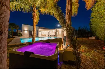 a house with a purple bath tub in front of a house at Luxury villa, private heated pool, jacuzzi, games in Oulad Akkou