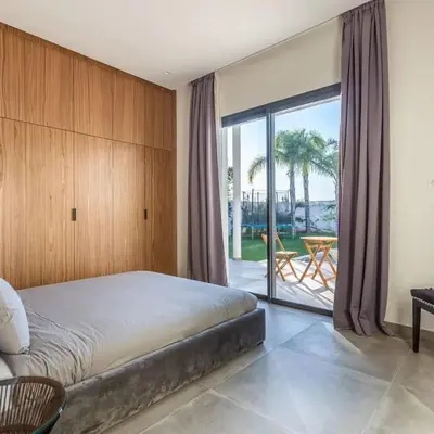 a bedroom with a bed and a sliding glass door at Luxury villa, private heated pool, jacuzzi, games in Oulad Akkou
