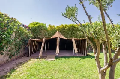 a tent is set up in a yard at Villa Belkis, games, Hammam, swimming pool, not overlooked in Oulad Akkou
