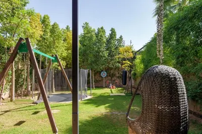 a metal swing in a park with a playground at Villa Belkis, games, Hammam, swimming pool, not overlooked in Oulad Akkou