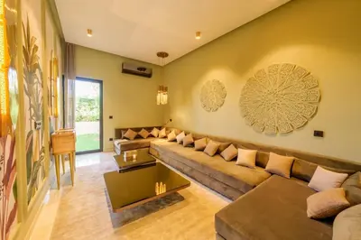 a living room with a couch and a table at Villa Belkis, games, Hammam, swimming pool, not overlooked in Oulad Akkou