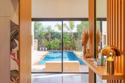 a living room with a swimming pool and a house at Villa Belkis, games, Hammam, swimming pool, not overlooked in Oulad Akkou