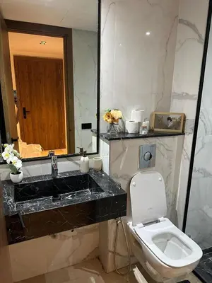 a bathroom with a sink and a toilet and a mirror at Appartement de luxe au coeur de Casa in Oulad Akkou