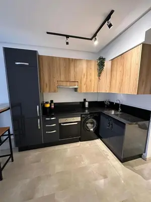a kitchen with black appliances and wooden cabinets at Appartement de luxe au coeur de Casa in Oulad Akkou