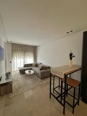 a living room with a couch and a table at Appartement de luxe au coeur de Casa in Oulad Akkou