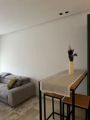a living room with a table and a couch at Appartement de luxe au coeur de Casa in Oulad Akkou