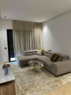 a living room with a couch and a glass table at Appartement de luxe au coeur de Casa in Oulad Akkou