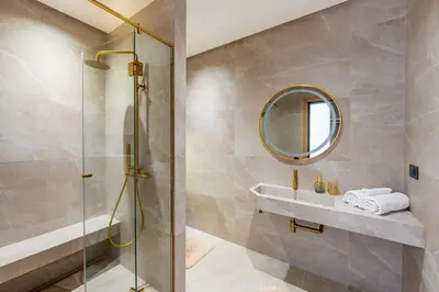 a bathroom with a shower and a sink and a mirror at New villa k, heated pool, Hammam in Oulad Akkou
