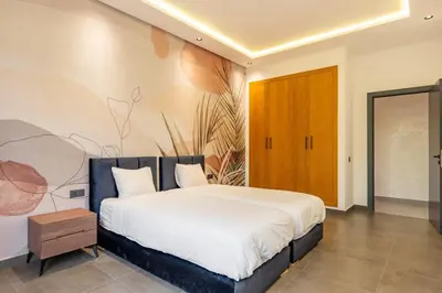 a bedroom with a large bed with a painting on the wall at New villa k, heated pool, Hammam in Oulad Akkou