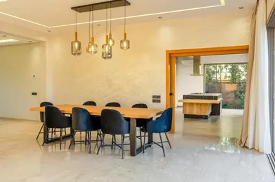 a dining room with a wooden table and chairs at New villa k, heated pool, Hammam in Oulad Akkou