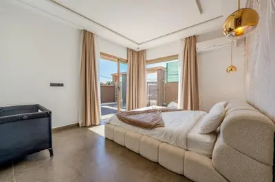 a bedroom with a large bed and a large window at New villa k, heated pool, Hammam in Oulad Akkou