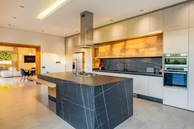 a large kitchen with a large black counter top at New villa k, heated pool, Hammam in Oulad Akkou