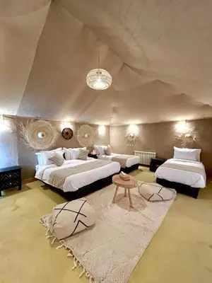 a large bedroom with two beds and a rug at lunara camp in Merzouga