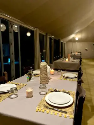 a long table with white plates and candles on it at lunara camp in Merzouga