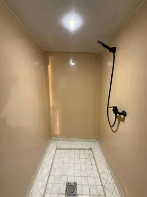 a bathroom with a shower with a light on the wall at lunara camp in Merzouga