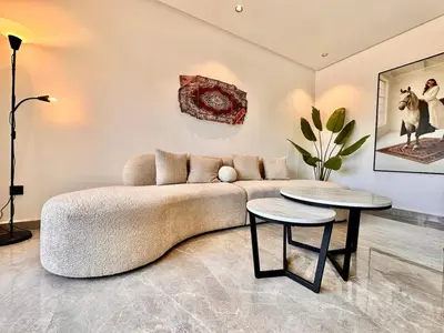 a living room with a couch and two tables at Cocon Elégant CFC, Pool, Gym & Parking Gratuit in Oulad Akkou