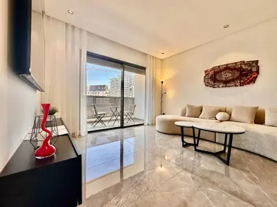a living room with a couch and a table at Cocon Elégant CFC, Pool, Gym & Parking Gratuit in Oulad Akkou