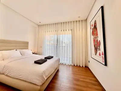 a bedroom with a large bed and a large window at Cocon Elégant CFC, Pool, Gym & Parking Gratuit in Oulad Akkou