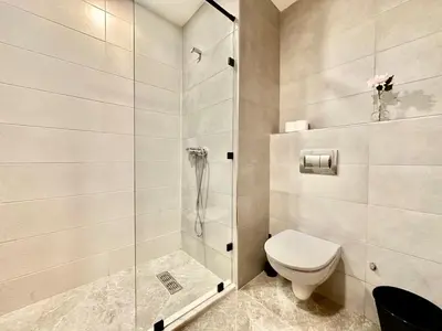 a bathroom with a toilet and a glass shower at Cocon Elégant CFC, Pool, Gym & Parking Gratuit in Oulad Akkou