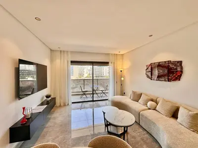 a living room with a couch and a table at Cocon Elégant CFC, Pool, Gym & Parking Gratuit in Oulad Akkou