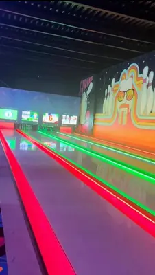 a bowling alley with purple lanes and neon lights at Belle appartement et spacieuse in Meknès