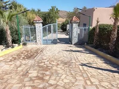 a gate to a house with a stone driveway at Tazouta Farm Villa with Private Pool & Mountain Views in Tazouta