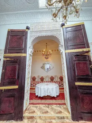 a dining room with a table and a chandelier at Dar Noor Fès in Fès