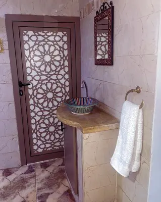 a bathroom with a shower with a door and a sink at Dar Noor Fès in Fès