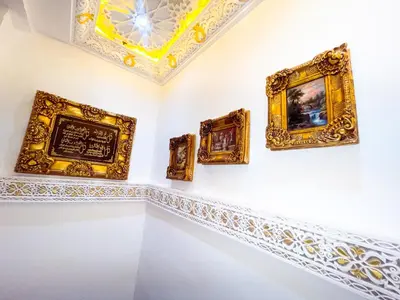 a room with gold frames on the wall at Dar Noor Fès in Fès