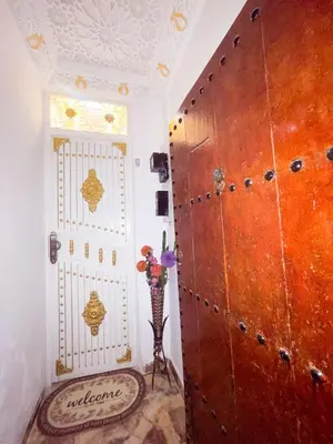 a room with a door and a vase of flowers next to it at Dar Noor Fès in Fès