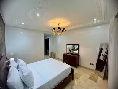 a bedroom with a bed and a chandelier at Chic & Spacious 4BR with Jacuzzi-Fez New City Stay in Fès