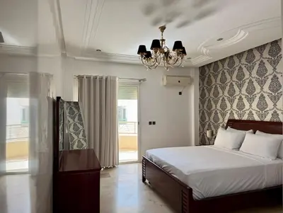 a bedroom with a bed and a chandelier at Chic & Spacious 4BR with Jacuzzi-Fez New City Stay in Fès