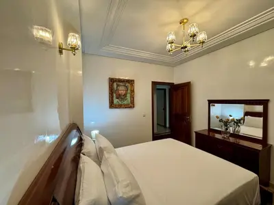 a bedroom with a bed and a mirror at Chic & Spacious 4BR with Jacuzzi-Fez New City Stay in Fès