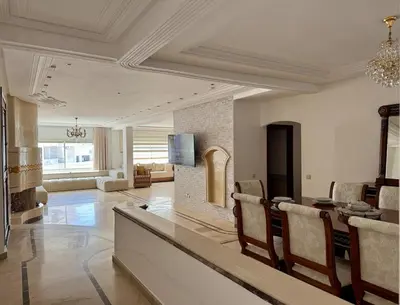 a large living room with a table and a fireplace at Chic & Spacious 4BR with Jacuzzi-Fez New City Stay in Fès