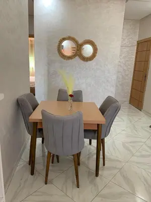 a dining room table with chairs and a mirror at prestige appartment in Fès