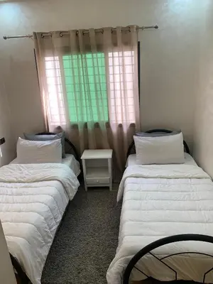 two twin beds in a room with a window at prestige appartment in Fès
