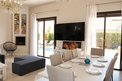 a dining room with a white table and chairs at Kridarek - Magnifique Villa avec piscine à Marrakech in Douar bel Rhanodour