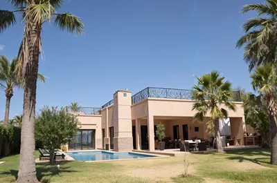 a house with a swimming pool and palm trees at Kridarek - Magnifique Villa avec piscine à Marrakech in Douar bel Rhanodour