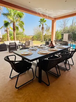 a large dining table with chairs and a pool at Kridarek - Magnifique Villa avec piscine à Marrakech in Douar bel Rhanodour