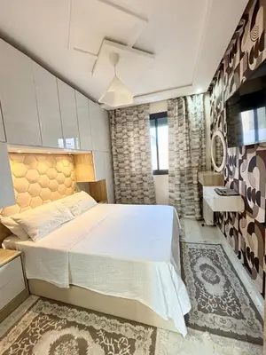 a bedroom with a large bed and a sink at Chic & Cozy Apartment in Tangier in Oulad Akkou