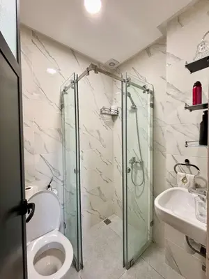 a bathroom with a shower and a toilet and a sink at Chic & Cozy Apartment in Tangier in Oulad Akkou