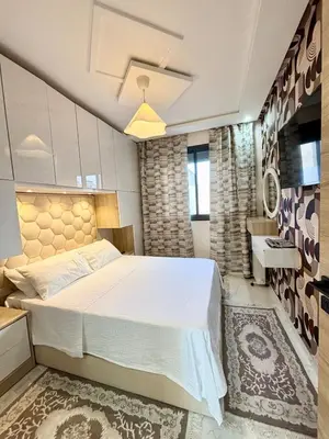 a bedroom with a large bed and a sink at Chic & Cozy Apartment in Tangier in Oulad Akkou