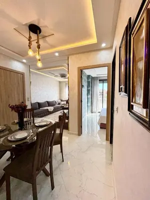 a dining room and living room with a table and chairs at Chic & Cozy Apartment in Tangier in Oulad Akkou
