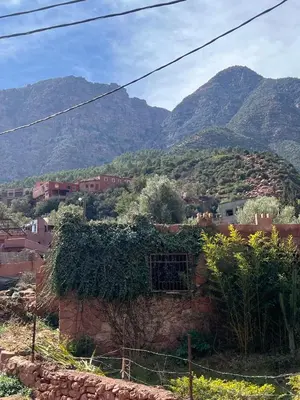 a village with mountains in the background at Ôtel Mrrakchi in Irghaf