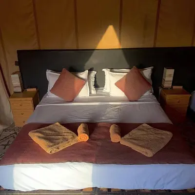 a bed with two towels and pillows on it at Overnight luxury camp merzouga in Merzouga