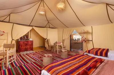 a room with a tent with a bed and a table at Overnight luxury camp merzouga in Merzouga